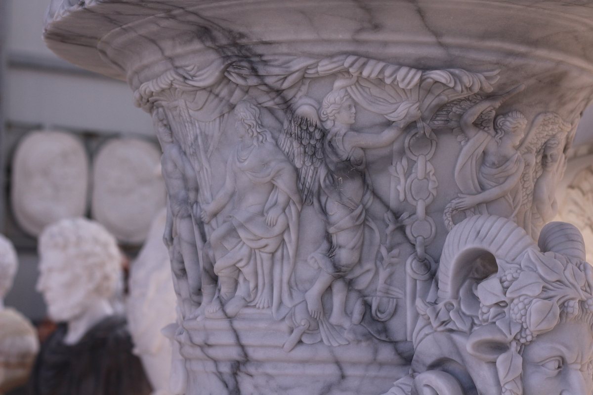 Carved marble capital with winged figures, garlands and a ram's head in relief